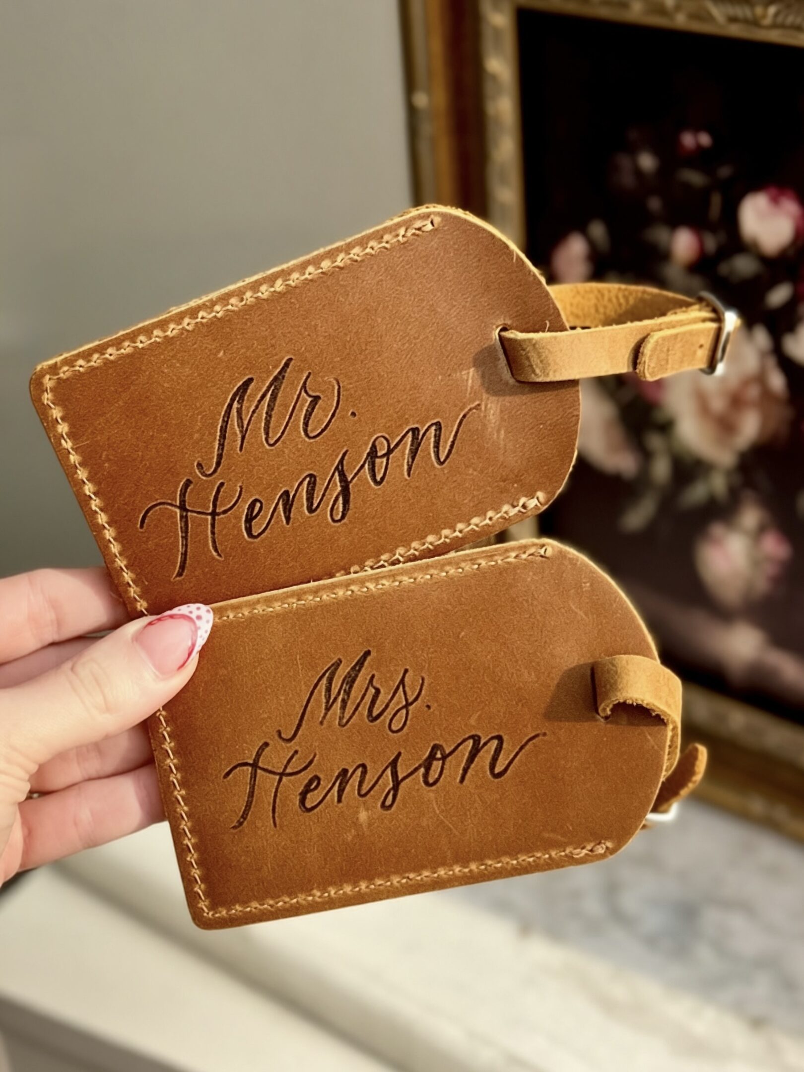 Two leather luggage tags engraved with 'Mr. Henson' and 'Mrs. Henson'.