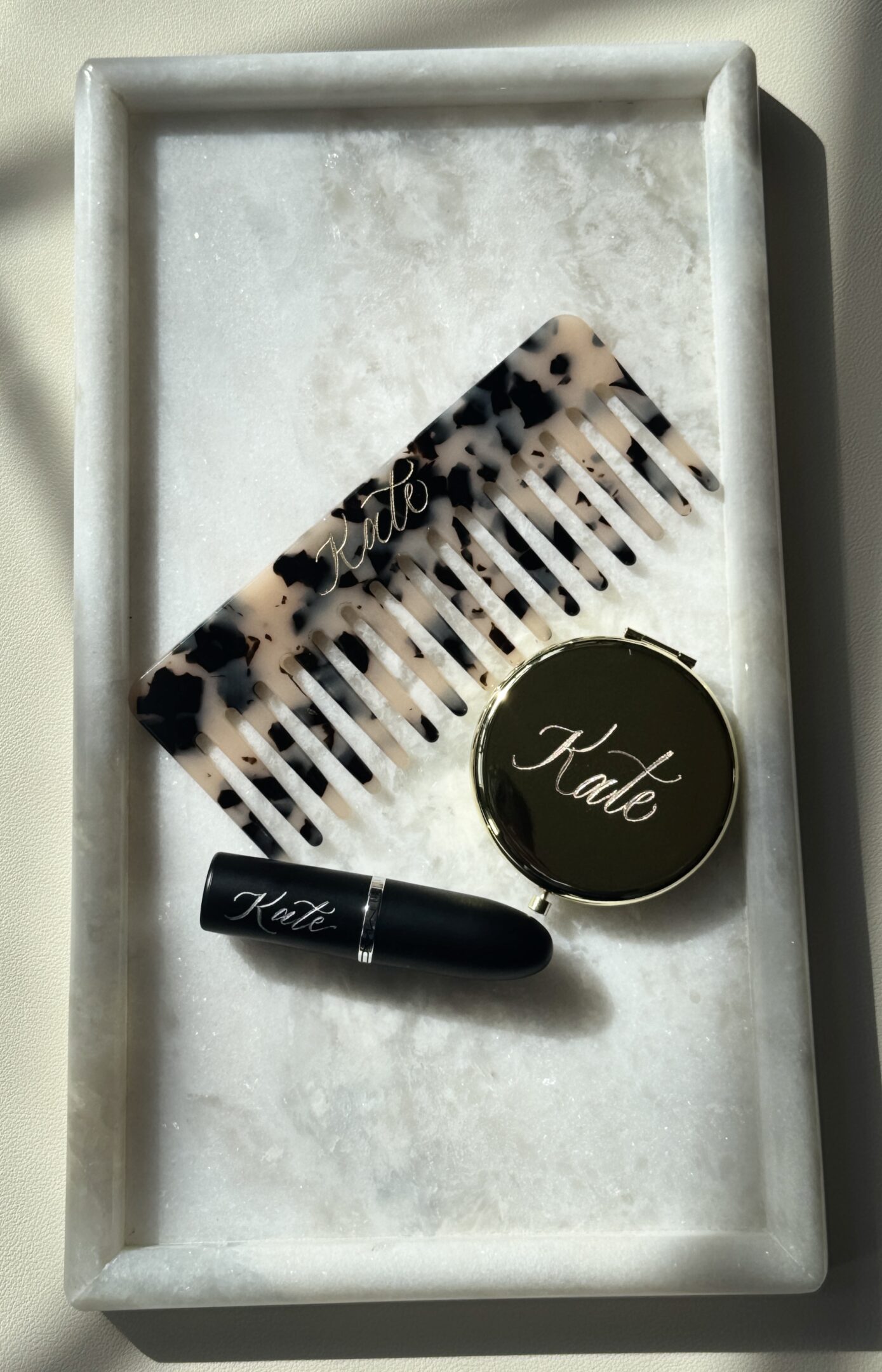 Makeup items including a leopard print brush, black lipstick, and a compact labeled 'Kale'.