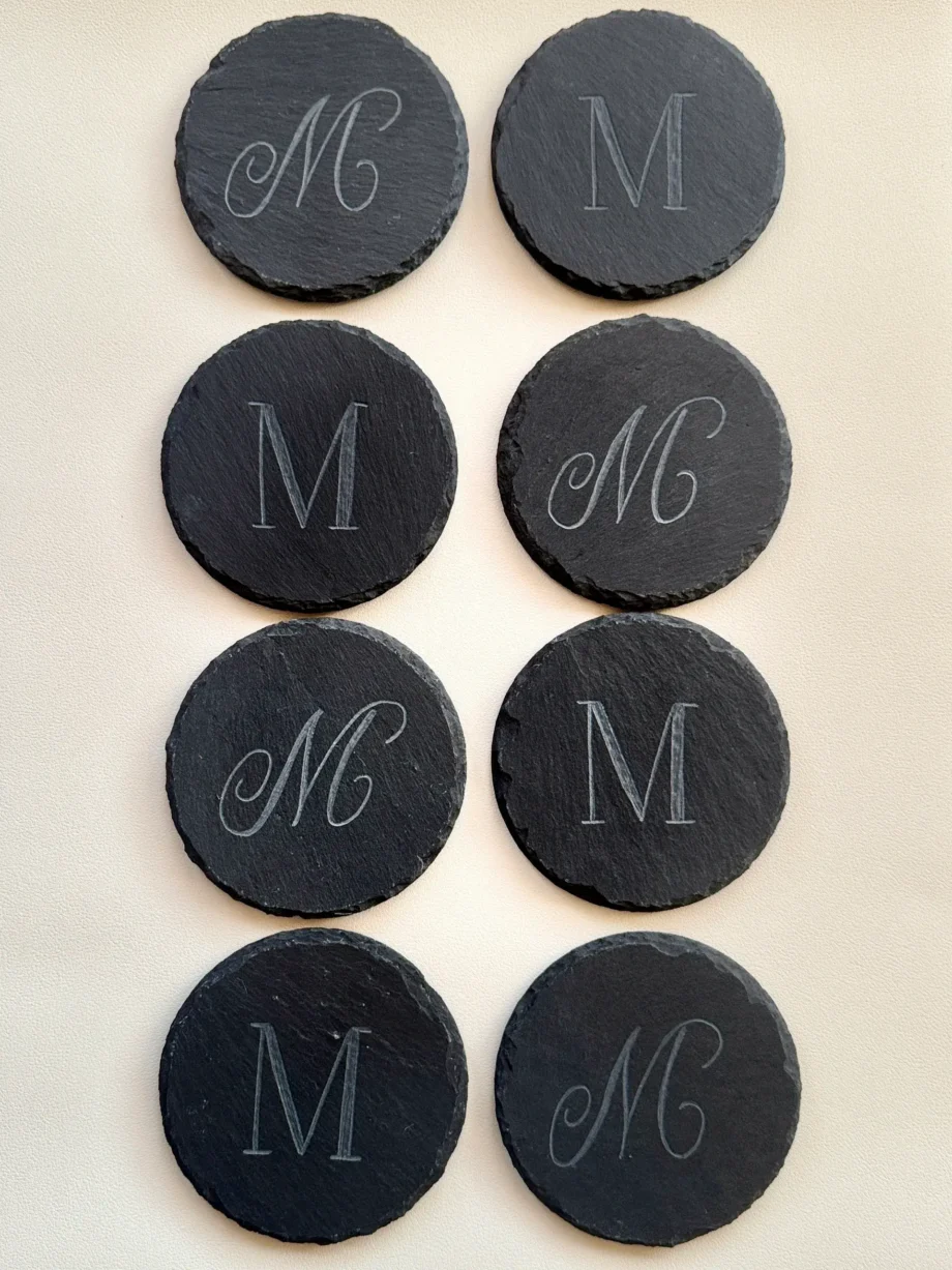 Black round tokens with white initials M and MC in elegant fonts.