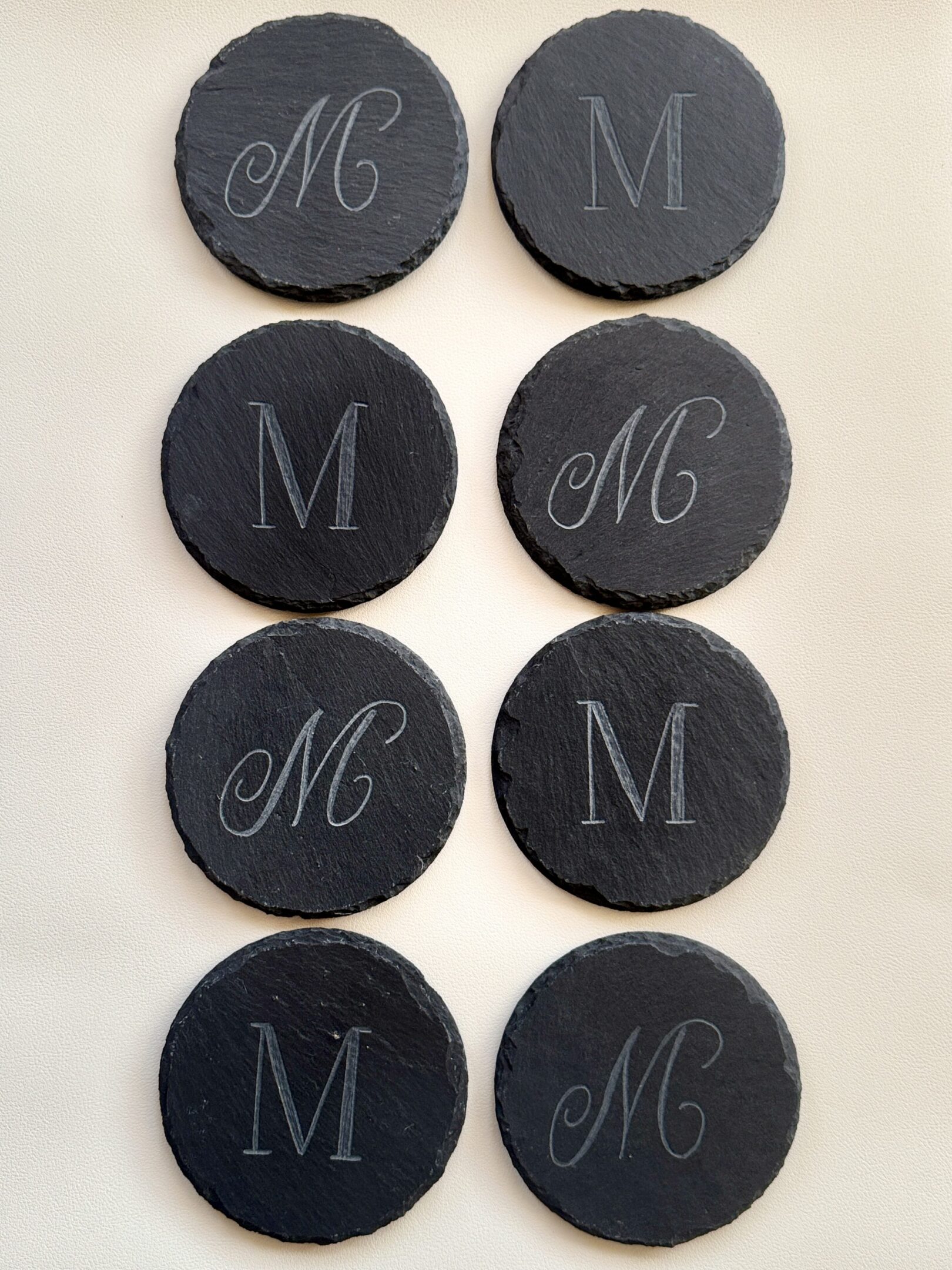 Black circular tokens with engraved letters 'M' and 'MG'.