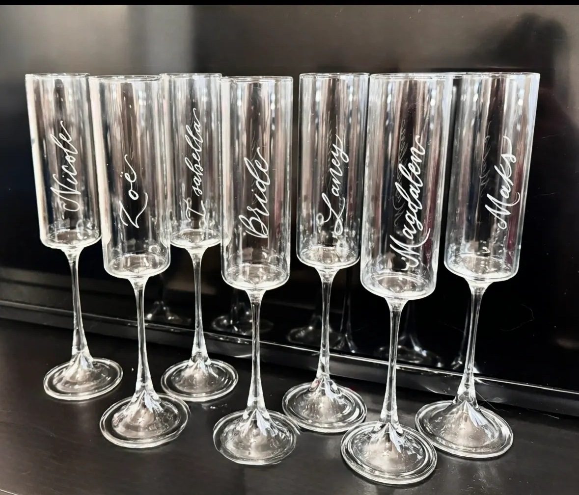 Elegant personalized champagne flutes with names etched on the glass.